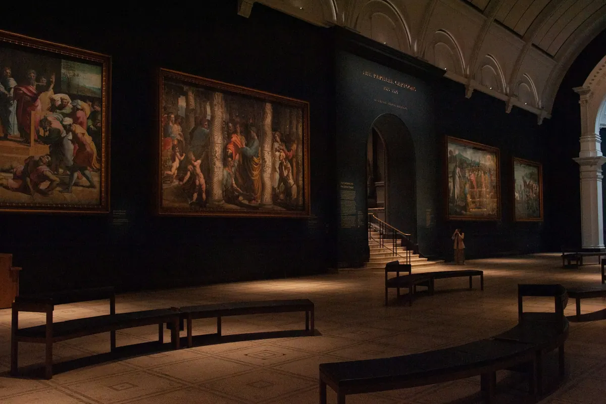 A grand museum gallery hung with paintings